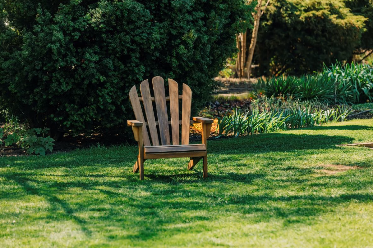 one-wooden-armchair-on-green-lawn-in-garder