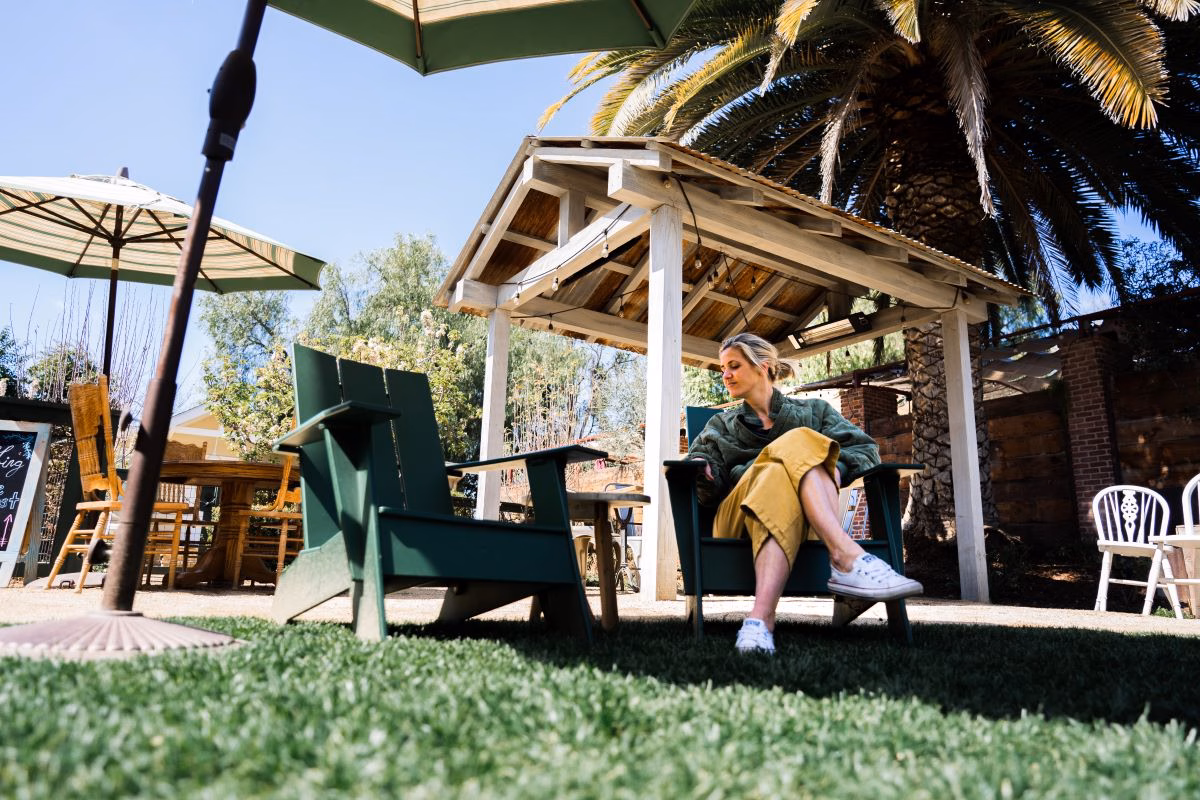 woman-relaxing-in-green-adirondack-chair-outdoors-2026-03-13-04-19-45-utc